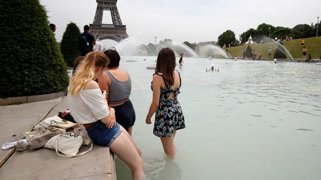 Còn ở Paris, nhiều người tập trung tại các đài phun nước gần tháp Eiffel để ngâm mình trong nước. Giới chức thủ đô Paris cũng quyết định thiết lập “phòng mát” trong các tòa nhà công trên khắp thành phố, mở cửa hồ bơi suốt đêm và lắp đặt thêm đài phun nước để giúp người dân đối phó với cái nóng gay gắt. Ảnh REUTERS