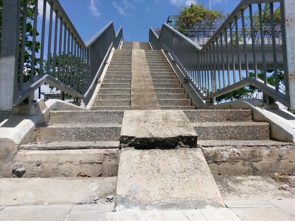Vị trí bậc thang lên cầu vượt phần vỉa hè bị “rớt” xuống khoảng 10 cm so với chân cầu.  Ảnh: M.Q