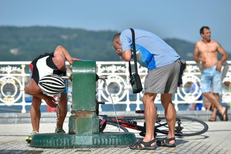 Người dân rửa mặt ở đài phun nước tại bãi biển La Concha, thành phố San Sebastian, Tây Ban Nha hôm 26.6 khi nắng nóng kỷ lục được ghi nhận khắp Châu Âu. Ảnh: AFP.