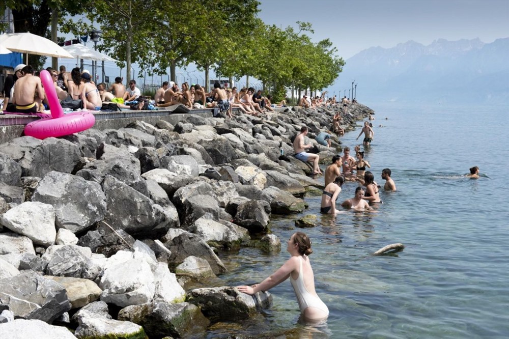 Người dân tắm ở hồ Geneva khi thời tiết nóng bức tại La Jetee de la Compagnie, Lausanne, Thụy Sĩ. Ảnh: EPA-EFE.