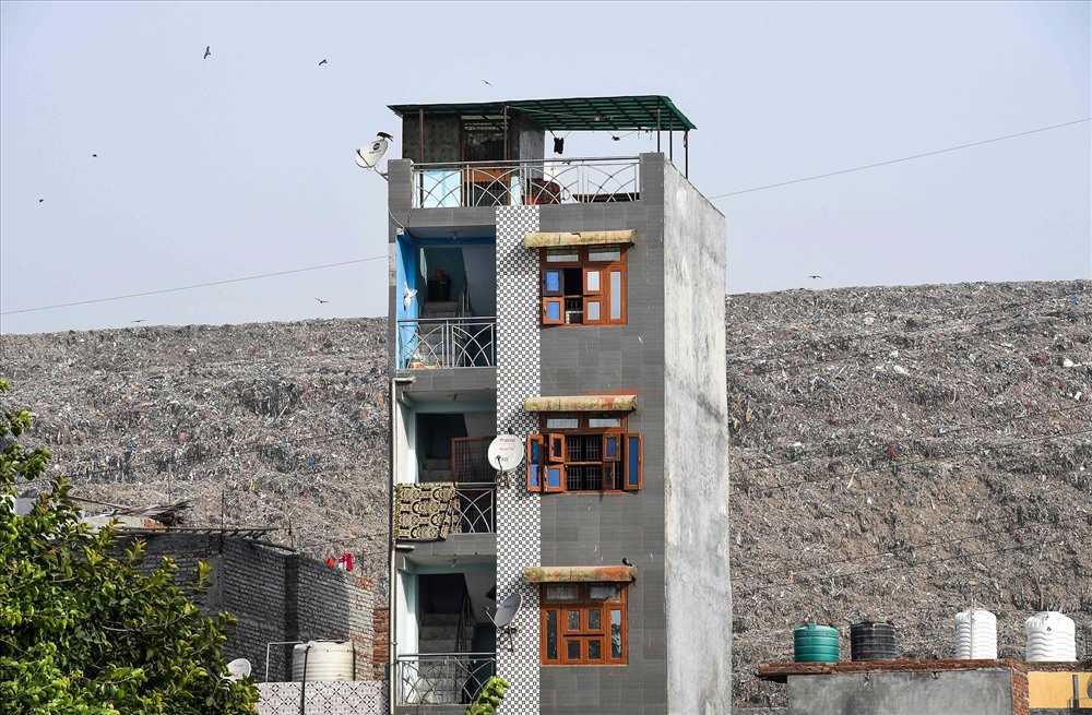 Hình ảnh một ngôi nhà được chụp, sau lưng là bãi rác cao ngất. Ảnh: AFP