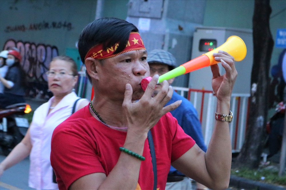 Một anh thanh niên thích thú với chiếc kèn cổ vũ hòa mình vào không khí sôi động tại phố đi bộ Nguyễn Huệ.