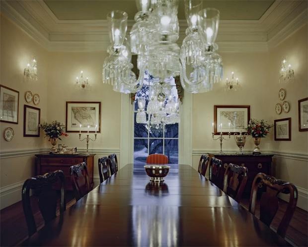 Phòng ăn trang trọng với bàn gỗ dài và đèn chùm pha lê lấp lánh. Ảnh: Engel & Volkers.