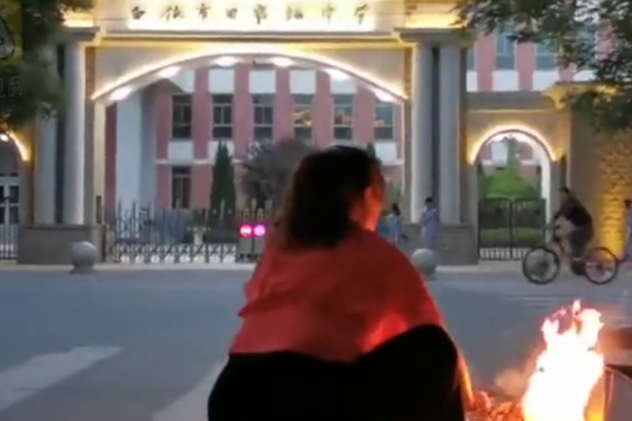 Phụ huynh Trung Quốc đốt đồ cúng ở bên ngoài trường thi. Ảnh: shanghai.ist.