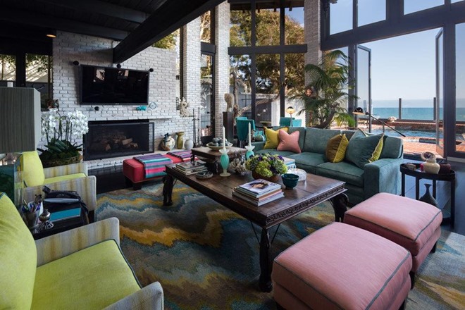 Phòng khách thoáng đãng, được bao phủ bởi ánh nắng California nhờ những tấm cửa kính cỡ lớn. Bộ sofa đa dạng màu sắc khiến không gian ở đây sinh động, đầy sức sống.