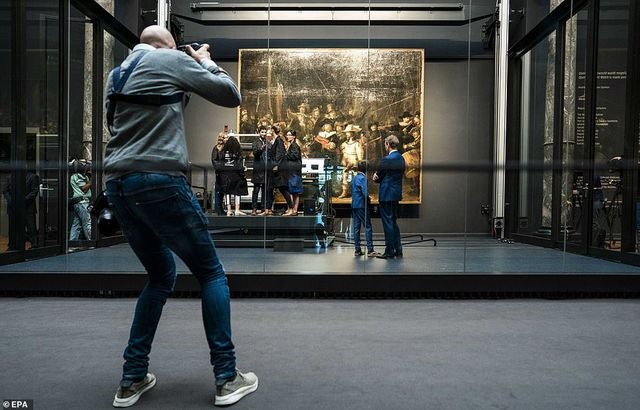 Làm việc bên trong phòng kính, các chuyên gia đang tiến hành giám định tình trạng bức tranh được thực hiện từ thế kỷ 17 khắc họa hoạt động dân phòng. Ảnh: Daily Mail.