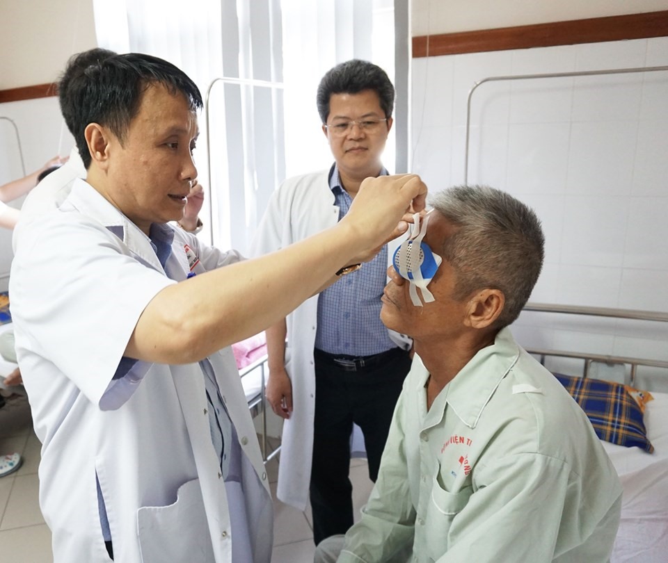 Gs. TS Phạm Như Hiệp - Giám đốc Bệnh viện Trung ương Huế trực tiếp bóc băng mắt cho bệnh nhân Phan Hữu Lạc. Ảnh: TTĐPGTQG