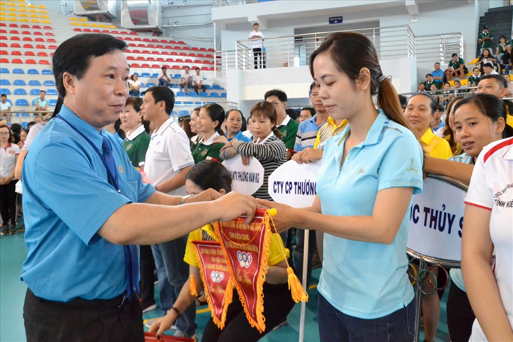 Chủ tịch LĐLĐ Kiên Giang Trần Thanh Việt tặng cờ cho các đơn vị tham dự hội thao. Ảnh: Lục Tùng