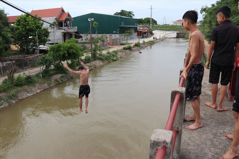 Mặc dù đã có biển cảnh báo nguy hiểm nhưng lượng người lên cầu tắm kênh ngày một đông hơn.