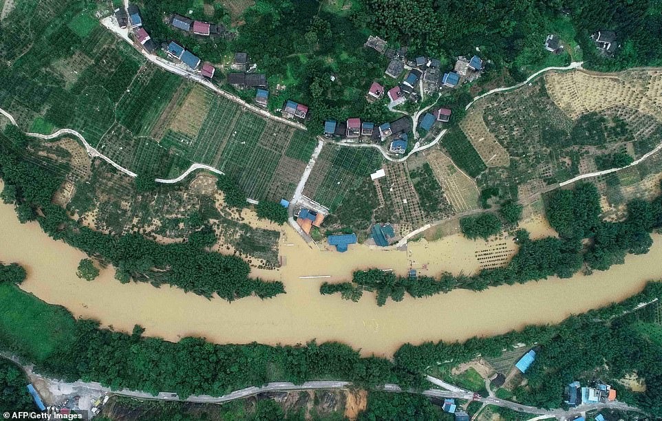 các dãy nhà nửa chìm và đường phố ngập nước ở một số khu vực bị ảnh hưởng nặng nhất bao gồm phía đông nam tỉnh Giang Tây và Hồ Nam lân cận. Ở trên, lũ lụt ở các trang trại ở quận Rong'an, miền nam Quảng Tây vào thứ ba