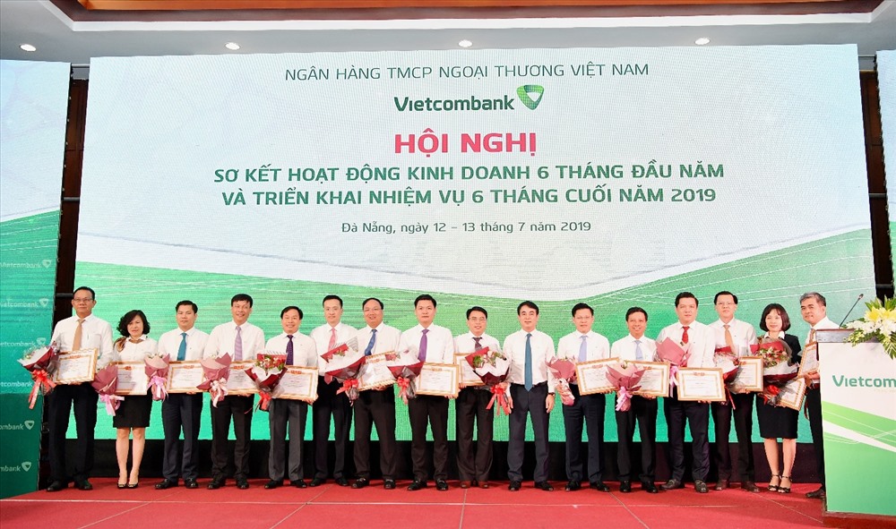 Chủ tịch HĐQT Nghiêm Xuân Thành (thứ 7 từ phải sang) và Tổng giám đốc Phạm Quang Dũng (thứ 6 từ trái sang) trao Giấy khen và tặng hoa cho 14 chi nhánh tiêu biểu trên một số mặt hoạt động 6 tháng đầu năm 2019.