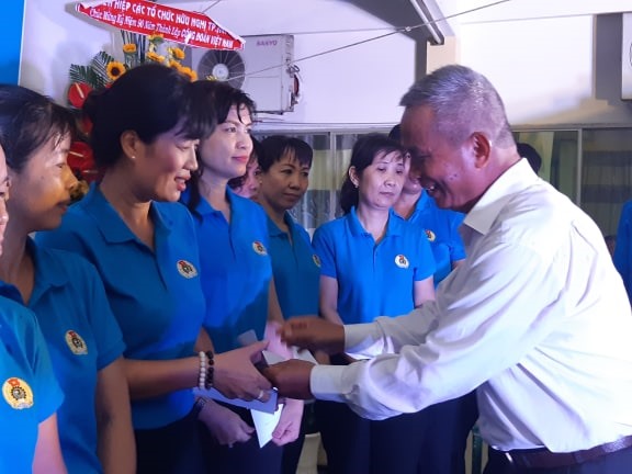 Nguyên Chủ tịch Tổng LĐLĐVN Đặng Ngọc Tùng (phải) trao quà khen thưởng các nhân viên gắn bó lâu năm với Văn phòng B. Ảnh Nam Dương