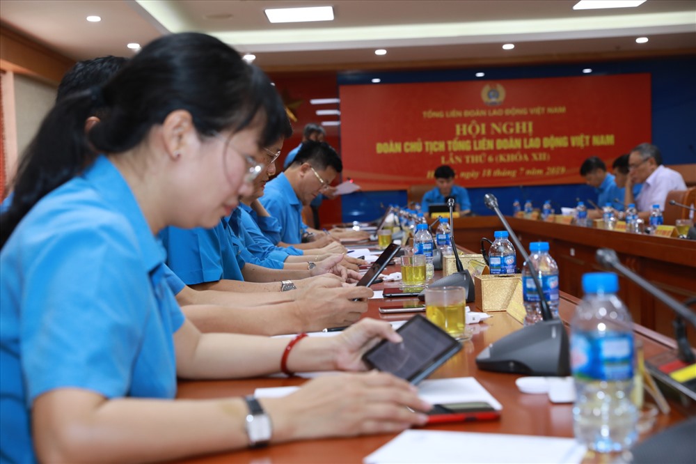 Các đại biểu nghiên cứu tài liệu qua máy tính bảng thay cho tài liệu bằng giấy như trước. Ảnh: Hải Nguyễn