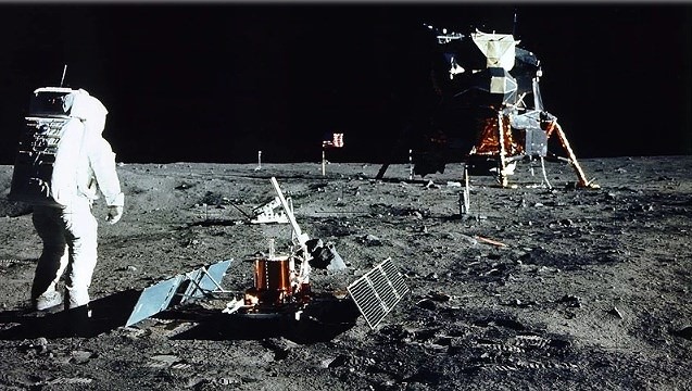 Phi hành gia Buzz Aldrin đứng gần một thí nghiệm khoa học trên bề mặt Mặt trăng.