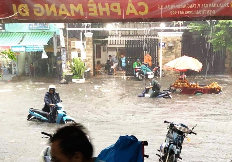 Cơn mưa lớn chiều 17.7 khiến nước ngập tới yên xe máy trên đường Lã Xuân Oai (quận 9).  Ảnh: CTV