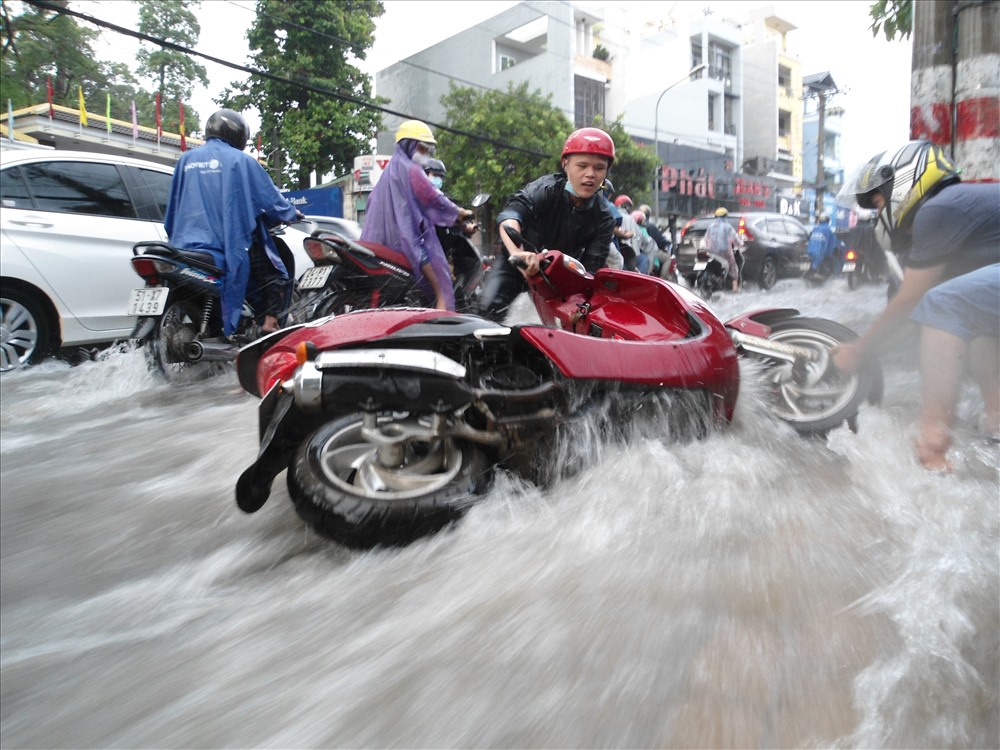 Mưa lớn, nước chảy xiết cuốn trôi xe máy trên đường Võ Văn Ngân (quận Thủ Đức).  Ảnh: Minh Quân