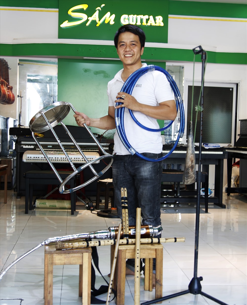 Chàng trai trẻ Trịnh Ngọc Huy Toàn với đam mê sáo trúc bên bộ sưu tập sáo tự chế của mình. Ảnh: Trường An