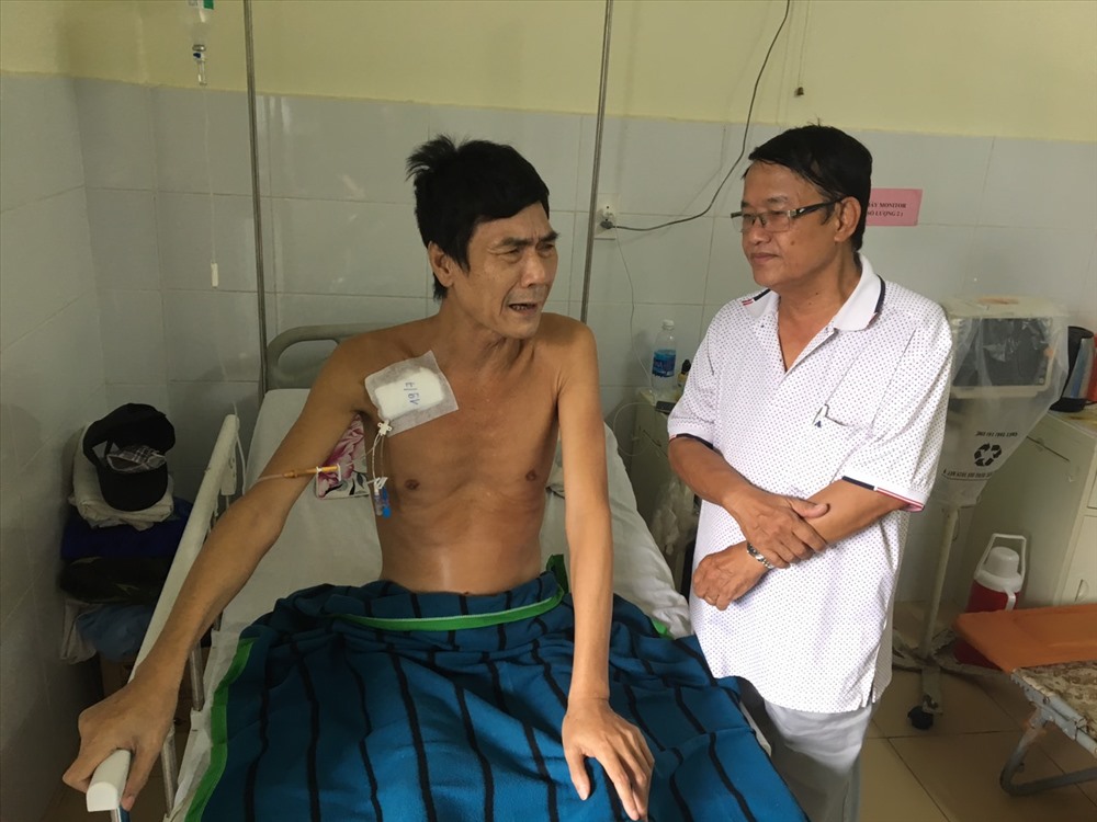 Nhà báo Huỳnh Dũng Nhân cùng mọi người đến thăm và tặng quà cho chú Phòng tại bệnh viện. Ảnh PV