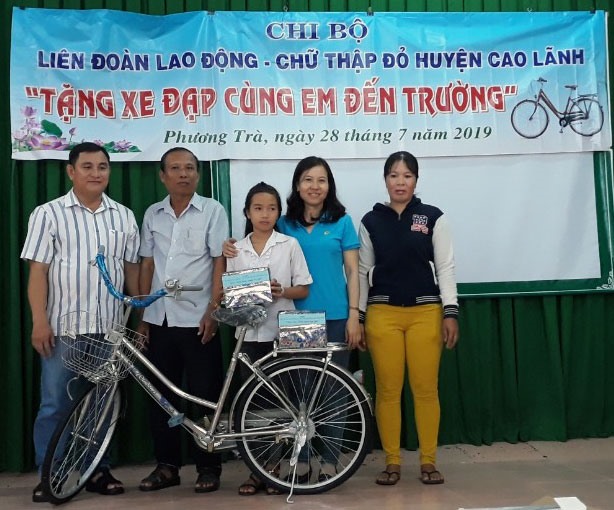 Chủ tịch LĐLĐ huyện Cao Lãnh  Phạm Thị Xuân Mai trao xe đạp và tập cho em Đặng Quyền Thanh Thảo. Ảnh:Hồng Lan