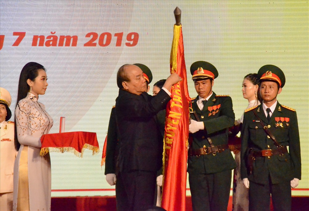Thủ tướng Nguyễn Xuân Phúc gắn Huân chương Độc lập hạng Nhất lên lá cờ truyền thống của tỉnh Kiên Giang. Ảnh: Lục Tùng