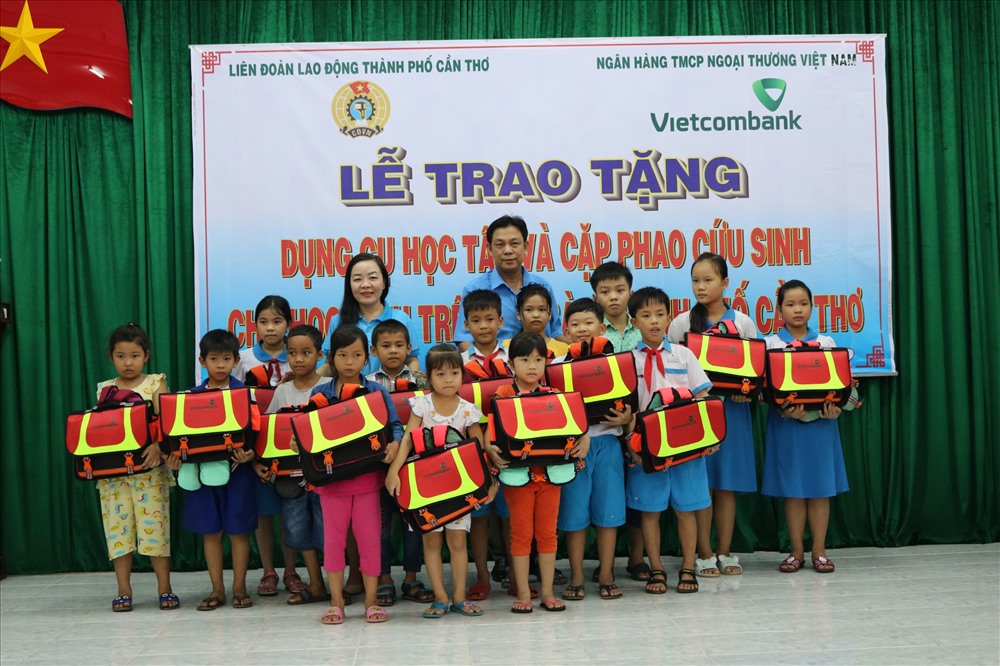 cán bộ LĐLĐ TP và LĐLĐ Quận Ô Môn trao quà cho các em học sinh.
