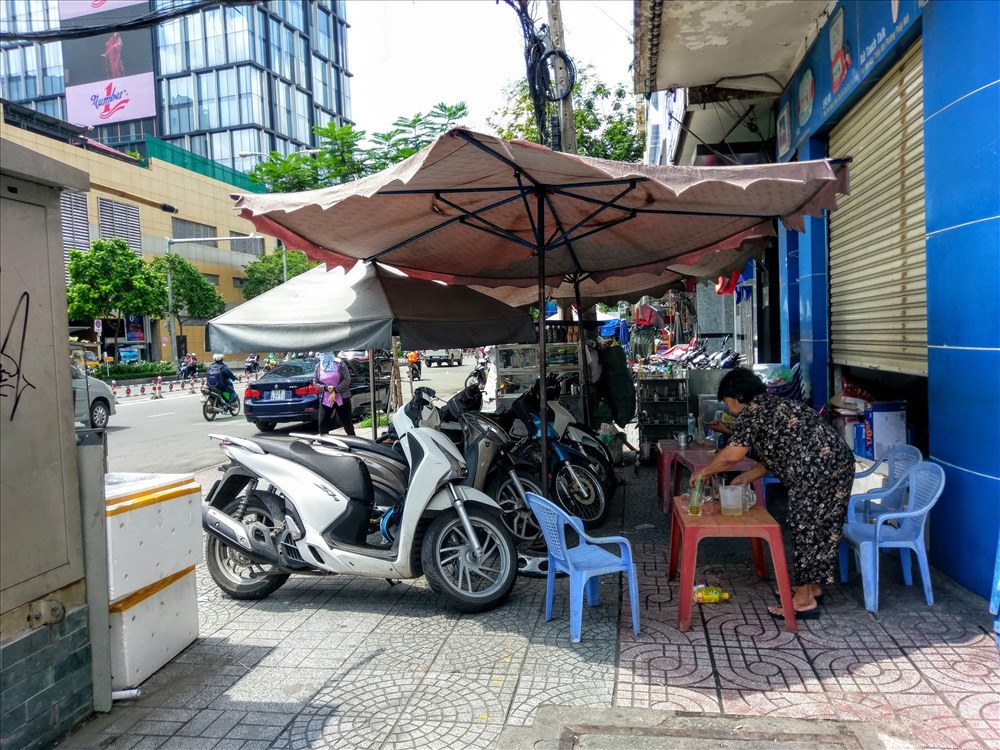 Người dân mở quán nước, dựng xe máy của khách chiếm trọn vỉa hè đường Nguyễn Thị Nghĩa (Q.1). Ảnh: M.Q