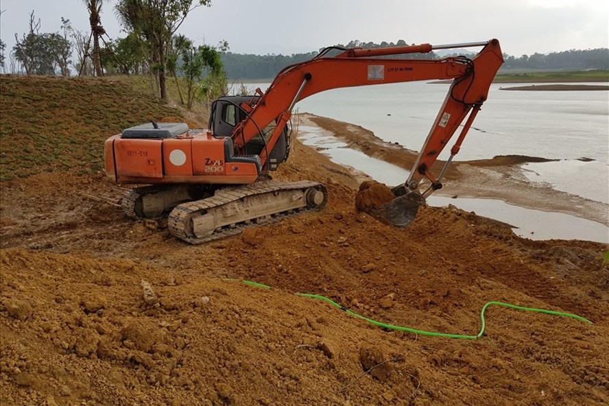 Tại khu đất đồi Mơ, máy xúc đang múc đất đã lấp xuống hồ Đồng Mô. Ảnh: NGUYÊN CHÍ