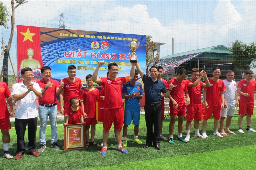 Phó chủ tịch LĐLĐ tỉnh Nguyễn Thanh Bình (bên trái), Bí thư Huyện ủy Hoàng Thái Phúc (bên phải) trao cúp cho đội vô địch. Ảnh: B.Mạnh