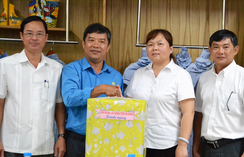 Ông Nguyễn Hữu Giang (thứ 3, phải sang) tặng máy nước nóng - lạnh trang bị cho phòng ăn tập thể CNLĐ Cty Lu An. Ảnh: Lục Tùng