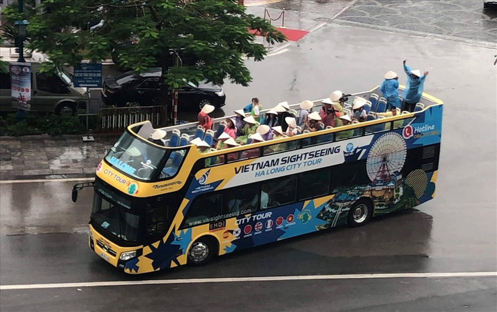 Du khách thích thú ngắm thành phố Hạ Long trên xe buýt 2 tầng. Ảnh: Nguyễn Hùng