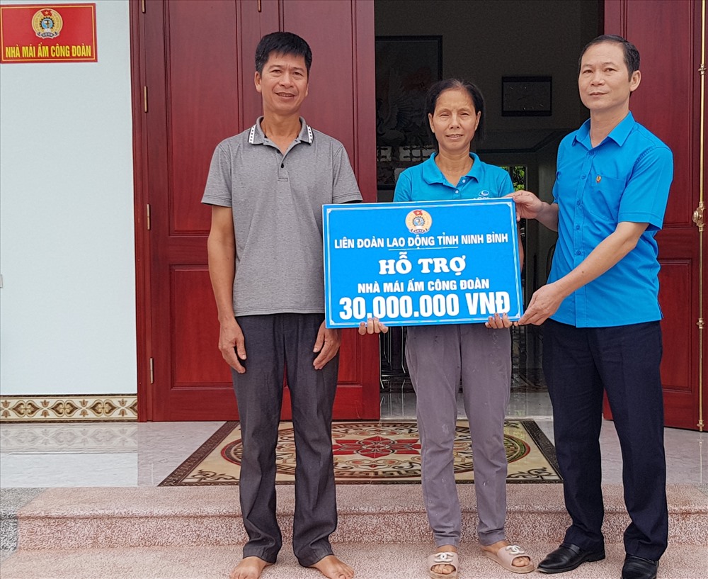 Đồng chí Trần Kim Long, Phó chủ tịch LĐLĐ tỉnh Ninh Bình trao tiền hỗ trợ cho gia đình chị Vũ Thị Định. Ảnh: NT