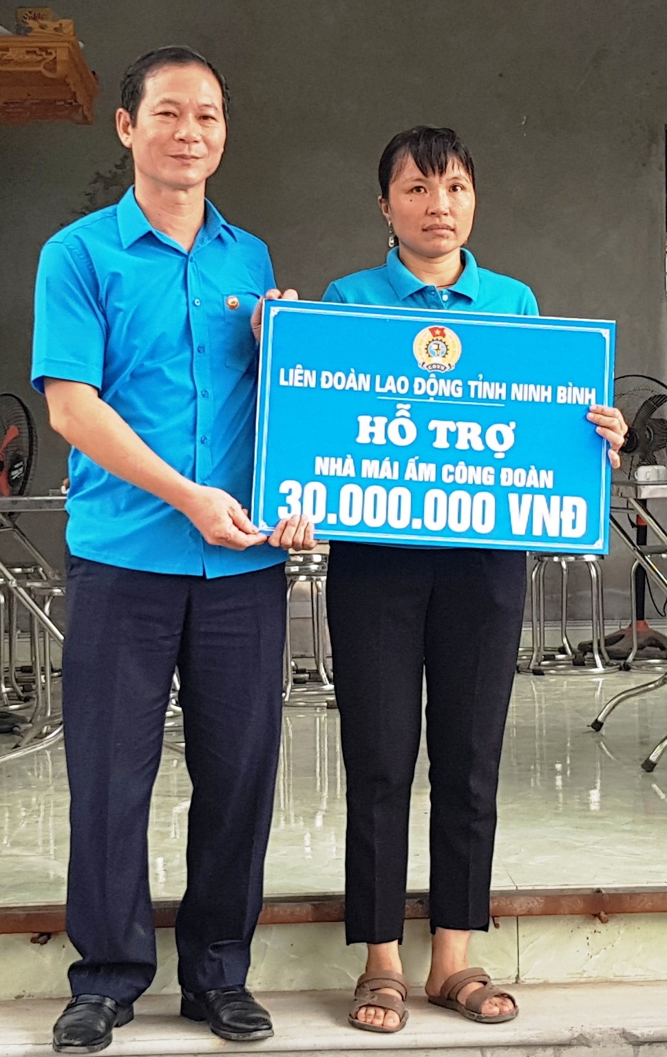 Đồng chí Trần Kim Long, Phó chủ tịch LĐLĐ tỉnh Ninh Bình trao tiền hỗ trợ cho gia đình chị Vũ Thị Thúy Hằng. Ảnh: NT