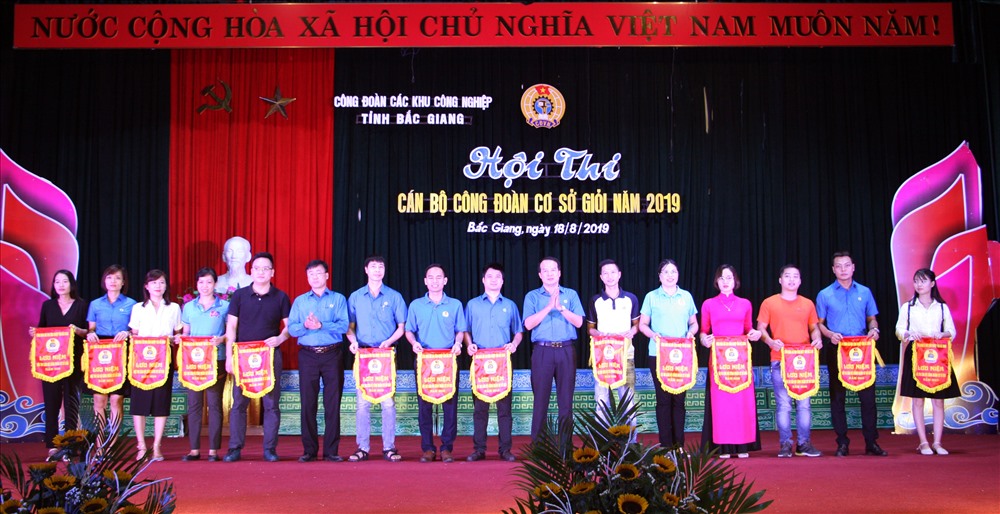 Lãnh đạo Liên đoàn Lao động tỉnh và Công đoàn Các khu công nghiệp tỉnh trao cờ lưu niệm cho các các đơn vị có thí sinh dự thi.