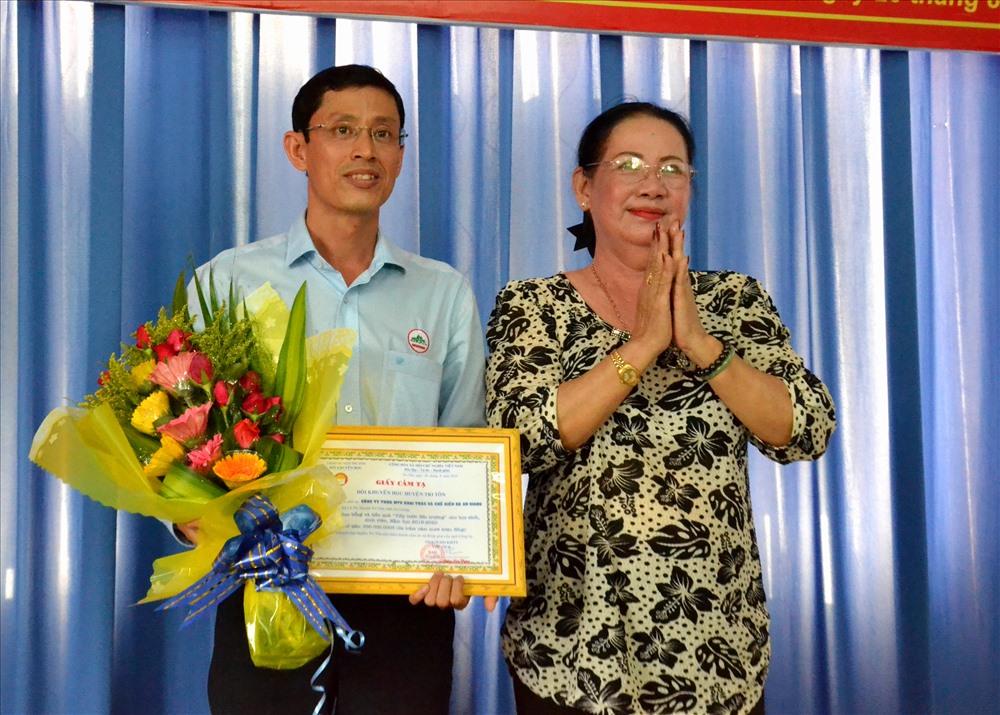 Bà Néang Kim Cheng, Chủ tịch Hội Khuyến học huyện Tri Tôn tặng hoa và Giấy tri ân cho đại diện Cty Angistone. Ảnh: Lục Tùng