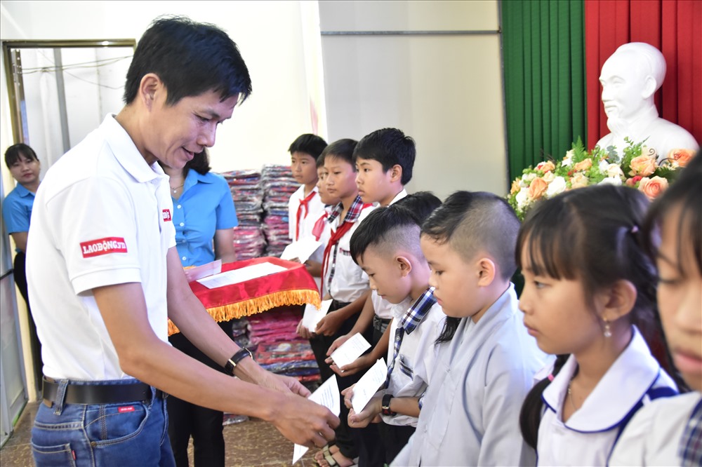 Ông Phan Ngọc Trường Nhân - đại diện Báo Lao Động tại ĐBSCL - trao học bổng và động viên các em học sinh. Ảnh: Thành Nhân