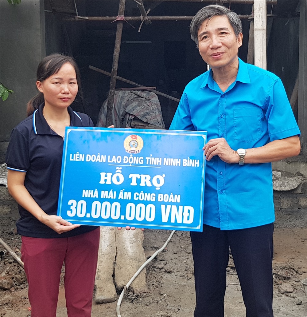 Đồng chí Phan Duy Linh, Phó chủ tịch LĐLĐ tỉnh Ninh Bình trao tiền hỗ trợ cho gia đình chị Dương Thị Thùy. Ảnh: NT