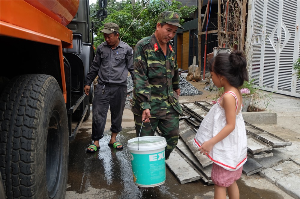 Thiếu tá Hiếu giúp người dân lấy nước sạch từ xe của bộ đội Cục Hậu cần.