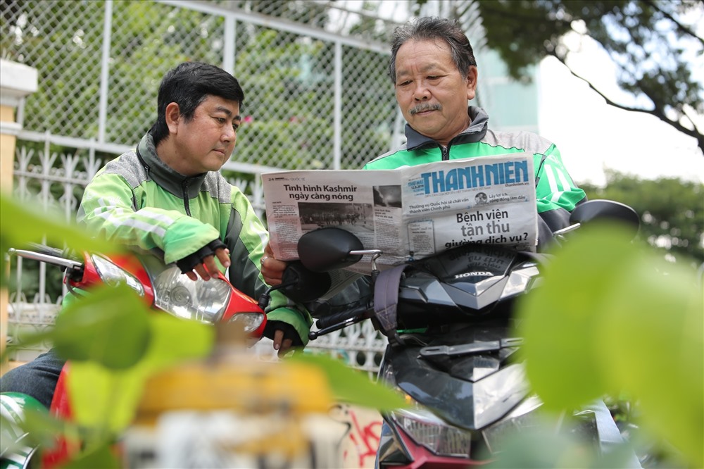 Anh Thanh Long (trái) có thể tránh được nhiều rủi ro khi thường xuyên trao đổi những tin tức về các sự cố liên quan đến xe cộ trên báo với đồng nghiệp.