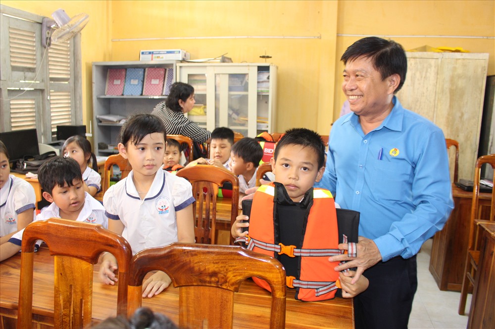 Chủ tịch LĐLĐ tỉnh Long An - ông Nguyễn Văn Quý - trao cặp phao cho học sinh.