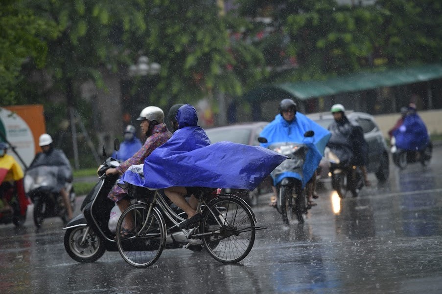 Trong sáng 3.8 do mưa kéo dài, khi ra đường người dân phải mang theo áo mưa, cộng với gió to khiến việc di chuyển khó khăn.