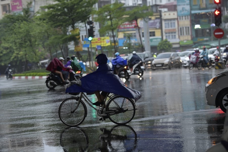 Trong sáng 3.8 do mưa kéo dài, khi ra đường người dân phải mang theo áo mưa, cộng với gió to khiến việc di chuyển khó khăn.