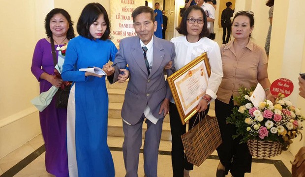 Nghệ sĩ nhân dân Trần Hạnh được người nhà dìu tới nhận danh hiệu. Ảnh: TTT.
