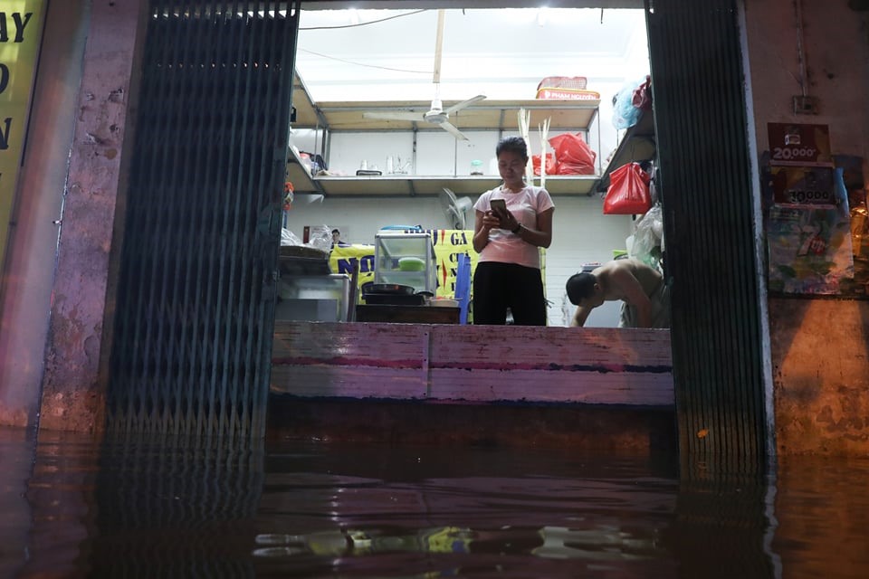 Tại phố Hoa Bằng (Cầu Giấy, Hà Nội) nước ngập khiến người dân phải dùng những tấm chắn, chắn ngang cửa ngăn không cho nước tràn vào nhà.