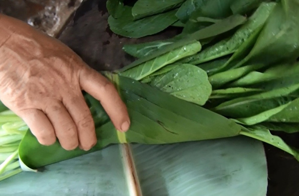 Dùng lá chuối gói rau, củ quả khi đi chợ để hạn chế sử dụng túi nilon gây ô nhiễm môi trường. Ảnh: HT.