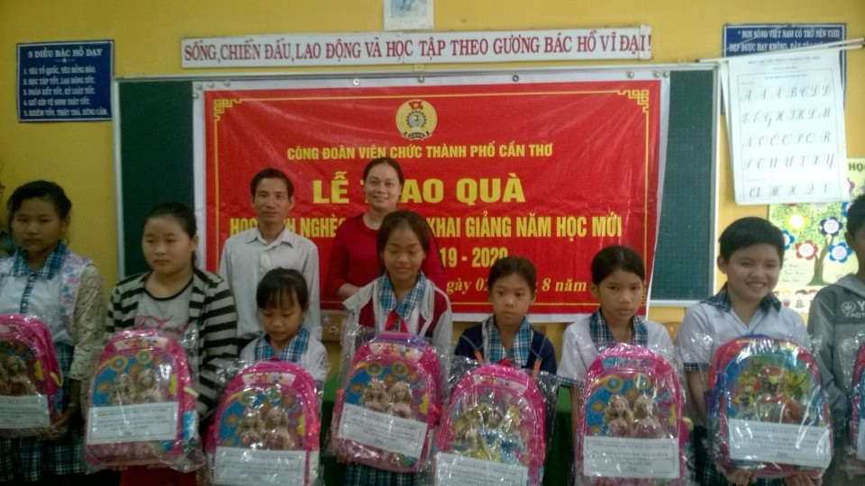 Bà Lê Thị Kim Chi và Ông Nguyễn Văn Phú trao quà và chúc mừng các em học sinh nhận quà. Ảnh: Thành Nhân