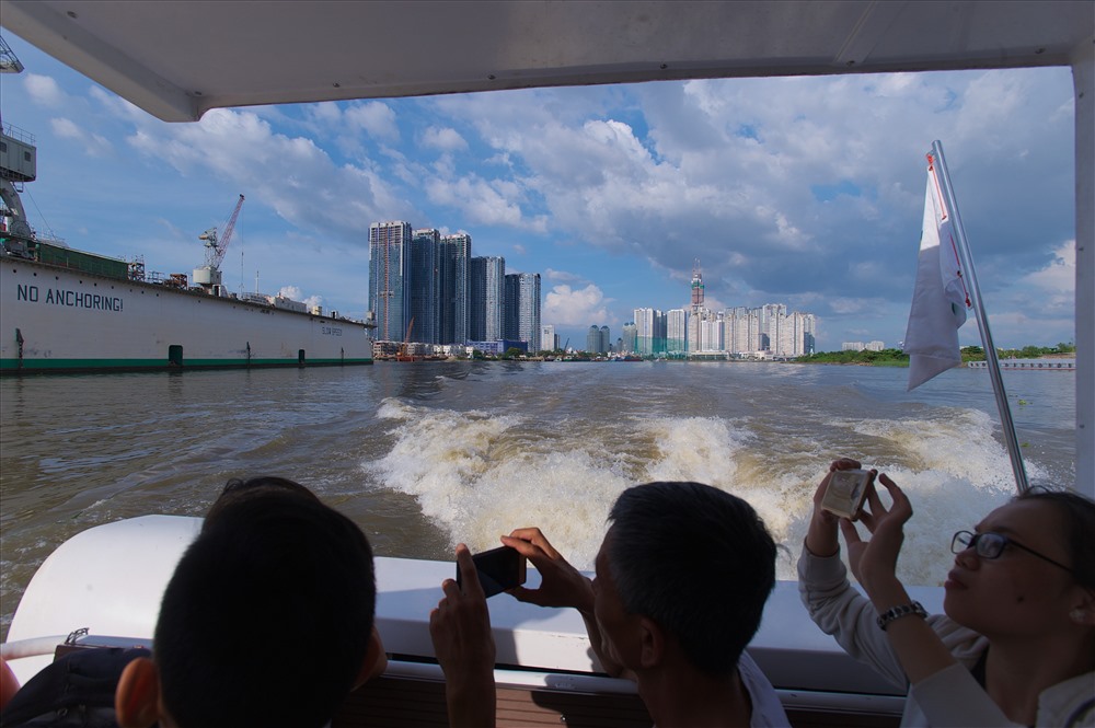 Khách thích thú chụp ảnh hai bờ sông Sài Gòn từ tàu buýt sông.  Ảnh: Ngọc Tiến