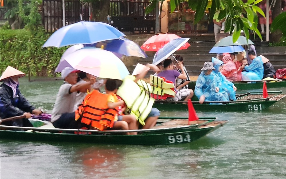 Nhiều du khách thích thu với cảm giác khám phá Tràng An dưới trời mưa. Ảnh: NT