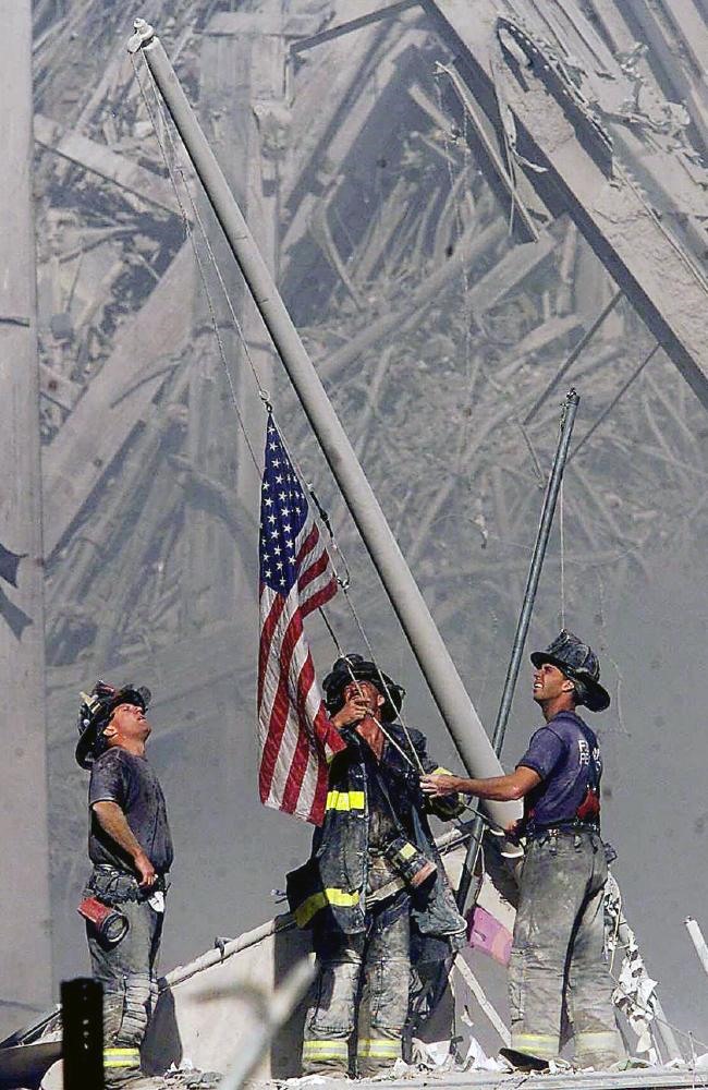 Ba lính cứu hỏa đang nâng một lá cờ tại Trung tâm Thương mại Thế giới ở New York. Ảnh: AP.