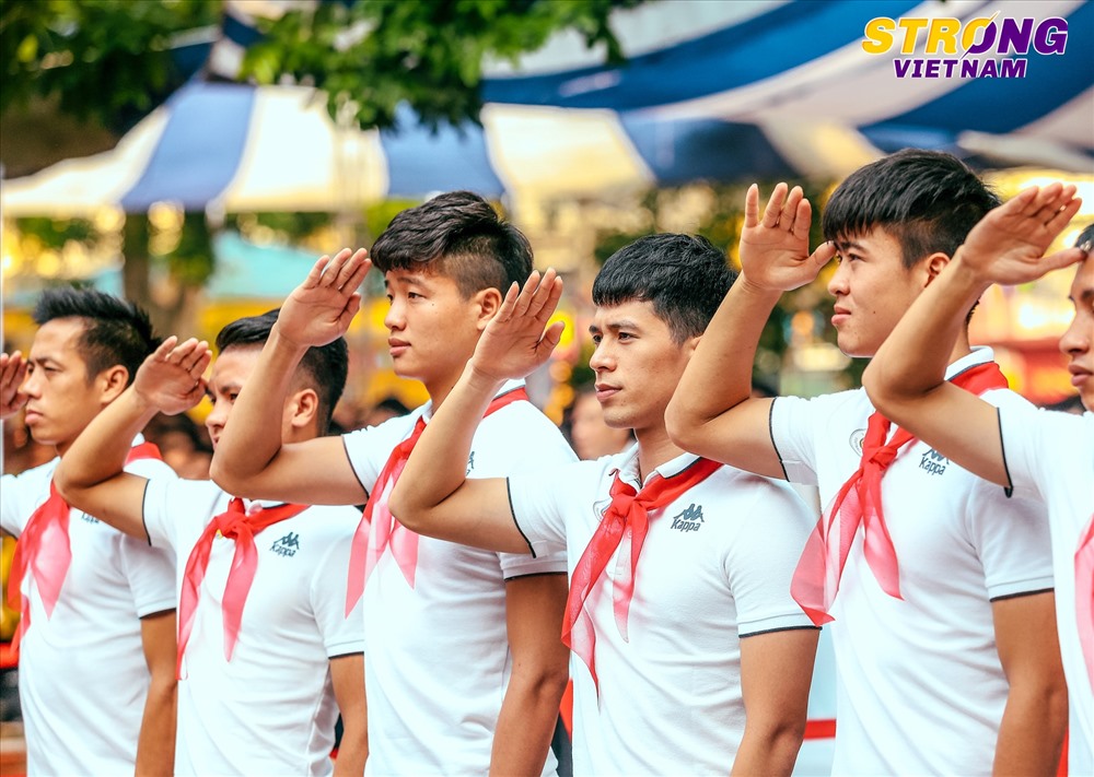 Các cầu thủ CLB bóng đá Hà Nội chào cờ đầu tuần cùng các em học sinh trường THCS Nguyễn Trường Tộ.