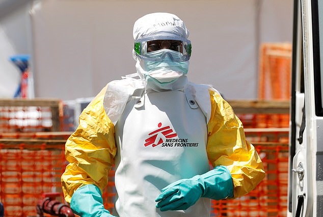 Một nhân viên mặc đồ bảo hộ khử trùng xe cứu thương chở bệnh nhân nghi mắc bệnh Ebola ở Congo. Ảnh: Mail.